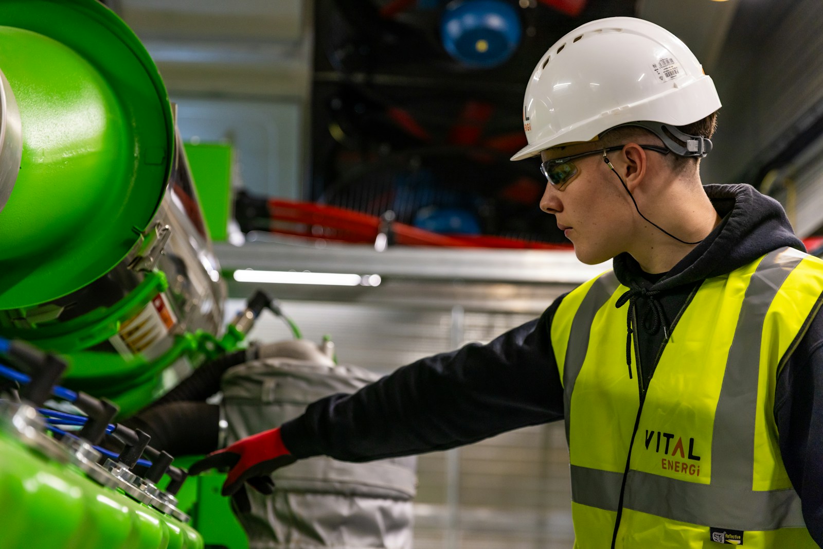 Engineer in hi-vis working on machinery in a modern factory